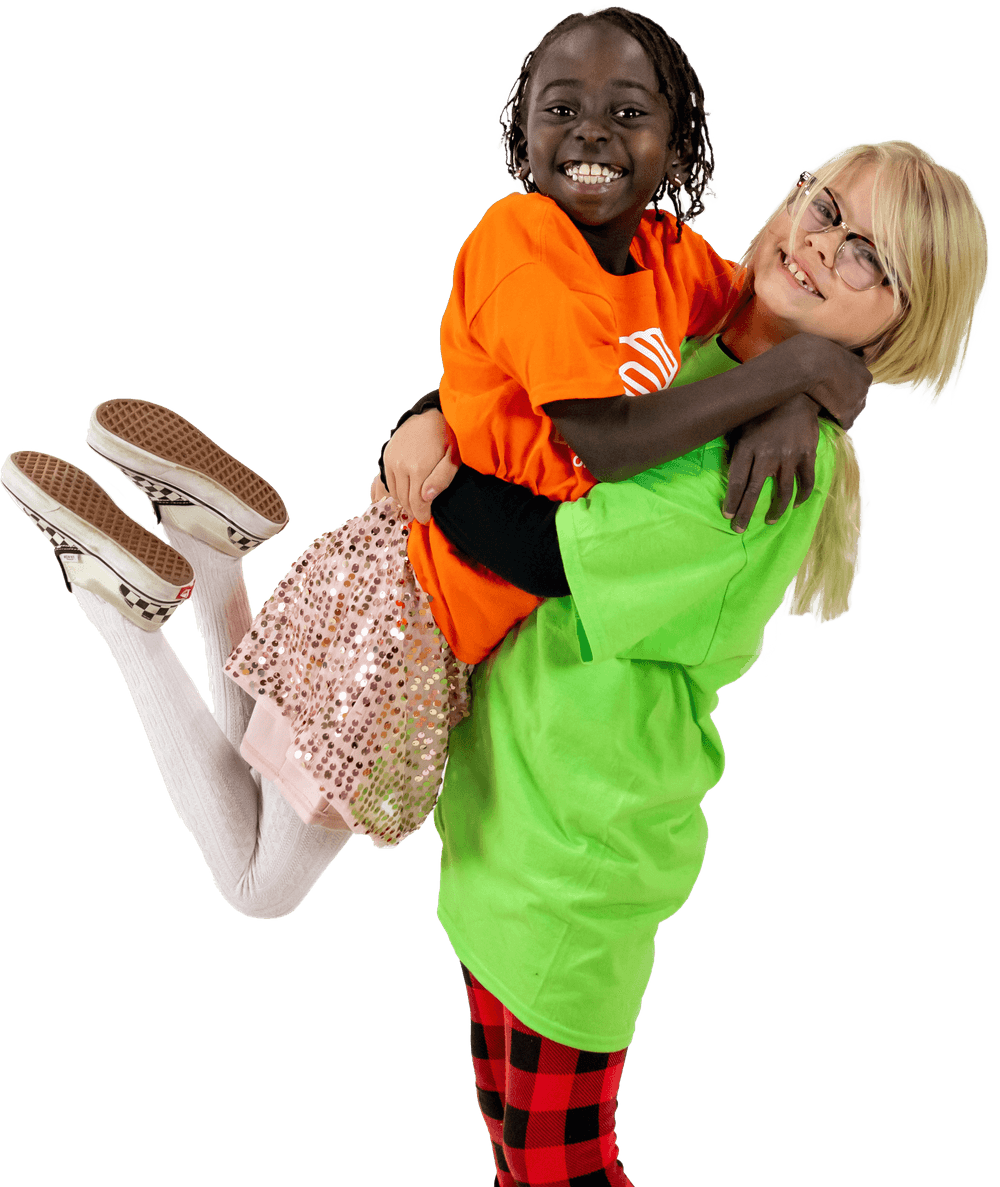 Two hugging and smiling girls wearing Boys & Girls Club of Truckee Meadows shirts